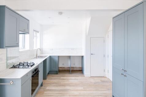 Bright and modern kitchen featuring soft blue c...