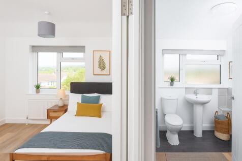 Bright and tidy master bedroom featuring a comf...