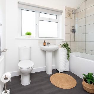 Bright and modern bathroom suite featuring a cl...