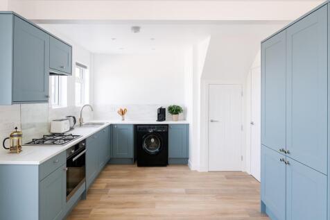 Bright and modern kitchen featuring elegant lig...