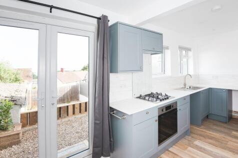 A bright and modern kitchen featuring sleek blu...