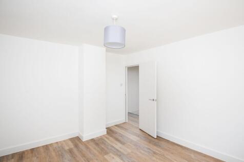 A bright, freshly painted room with clean white...