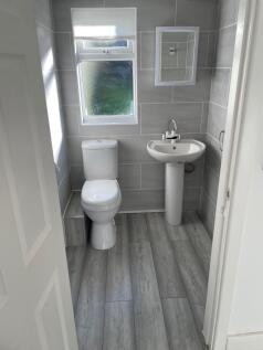 A clean and modern bathroom featuring grey tile...