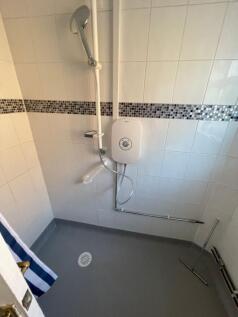 A clean and modern bathroom with white tiled wa...
