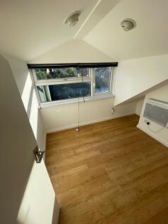 A bright and clean small room with wooden floor...