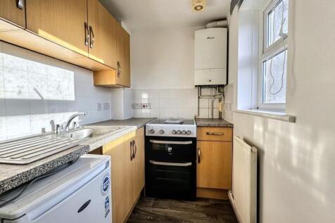 Bright and tidy kitchen featuring wooden cabine...