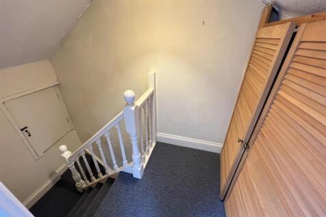 A clean and well-maintained hallway with carpet...