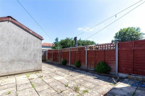 A bright and sunny paved garden area with well-...