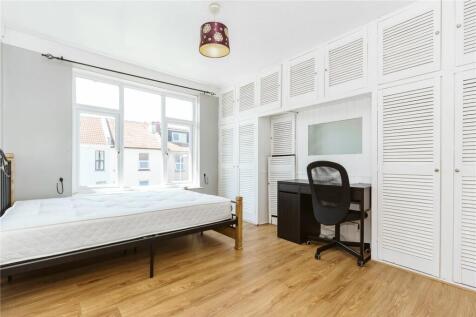A bright double bedroom featuring large windows...