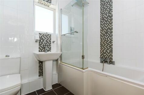 Bright and modern bathroom suite featuring a cl...