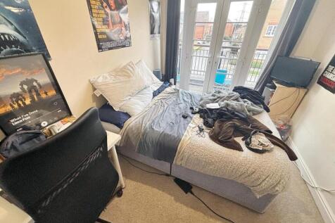 A cozy double bedroom featuring large windows t...