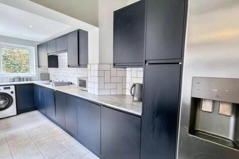 Modern kitchen with sleek black cabinets, white...