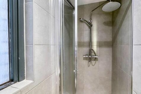 A modern bathroom suite featuring a large rain ...
