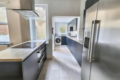 Modern kitchen with sleek grey cabinetry and st...