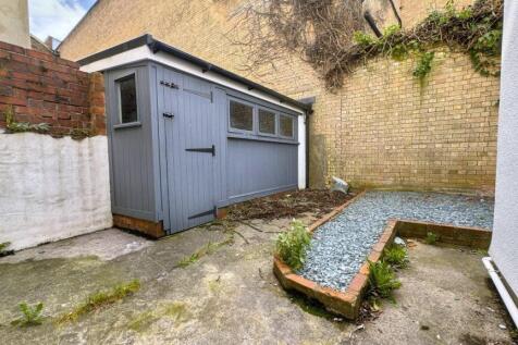 A cozy, enclosed garden space featuring a small...