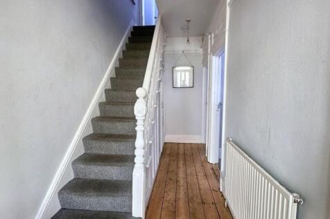 A clean and simple hallway featuring wooden flo...