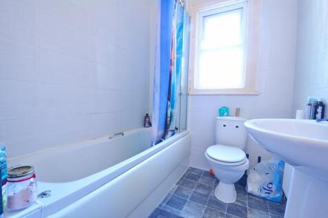 A bright and clean bathroom suite featuring a f...