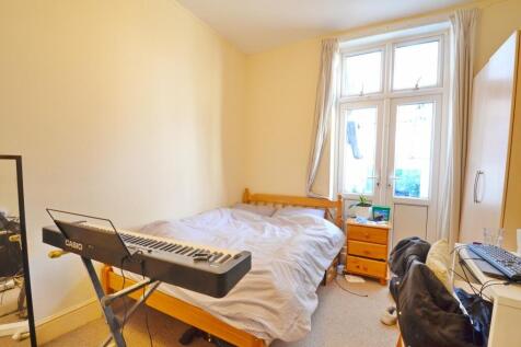 A cozy single bedroom featuring a comfortable b...