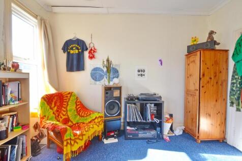 A cozy single bedroom featuring a comfortable c...