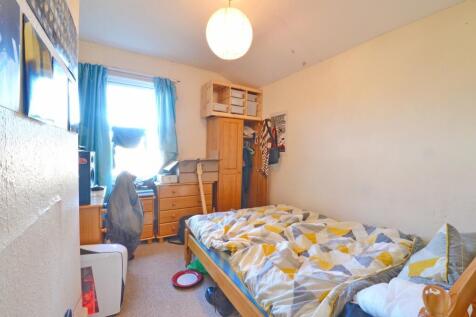 Cozy single bedroom featuring a neatly made bed...