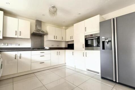 Bright and modern kitchen featuring sleek white...