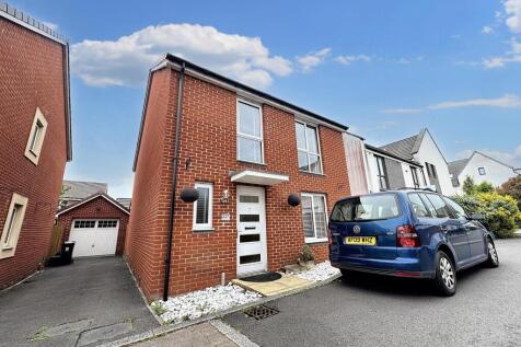 A modern semi-detached red brick house with a c...
