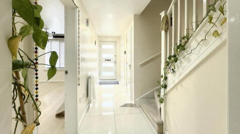 A bright and clean hallway featuring glossy whi...