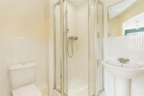 Bright and clean bathroom suite featuring a wal...