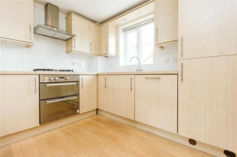 Bright and clean kitchen featuring light wood c...