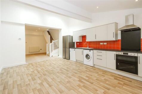 A modern, clean kitchen space featuring light w...