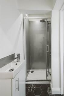 A modern compact bathroom featuring a sleek sho...