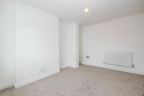 A clean, simple room with white walls and carpe...