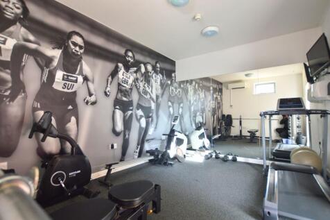 Well-equipped gym room featuring cardio machine...
