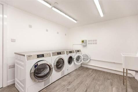 Bright and clean laundry room featuring multipl...