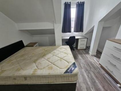 Bright double bedroom featuring a large bed, a ...