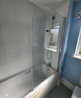 Bright and clean bathroom suite featuring a mod...