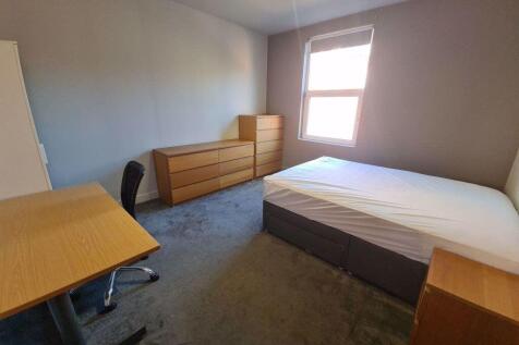 Bright and tidy master bedroom featuring a comf...