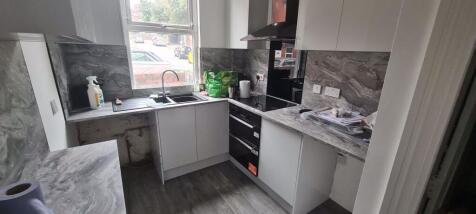 A modern kitchen featuring sleek white cabinetr...