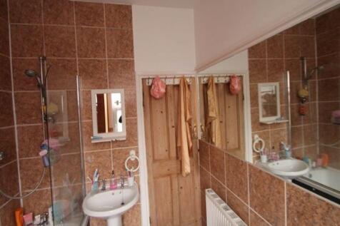 Bright and clean bathroom suite featuring a whi...