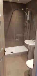A modern bathroom featuring a spacious walk-in ...