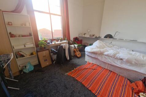A cozy bedroom with a large window allowing amp...