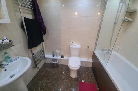 A bright and clean bathroom suite featuring a f...