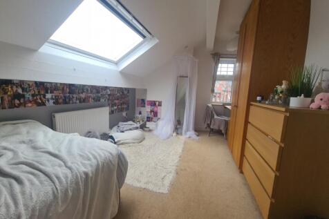 A cozy single bedroom featuring a comfortable b...