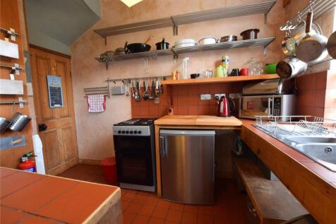 A cozy kitchen with warm terracotta tiles and w...