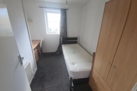 A compact, tidy single bedroom featuring a sing...