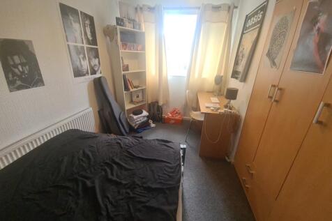 A cozy single bedroom featuring a neatly made b...