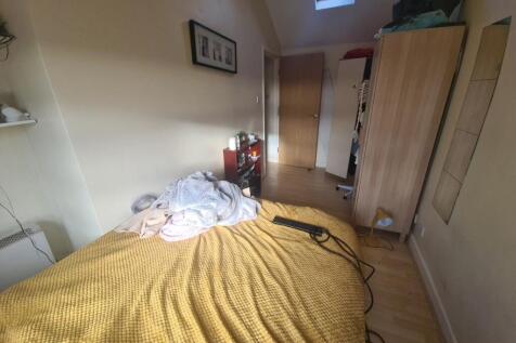 A cozy bedroom featuring a comfortable single b...