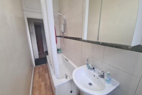 Bright and clean bathroom featuring a bathtub w...
