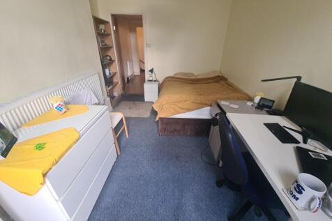 A cozy single bedroom featuring a comfortable b...