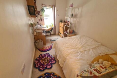 A cozy single bedroom featuring a comfortable s...